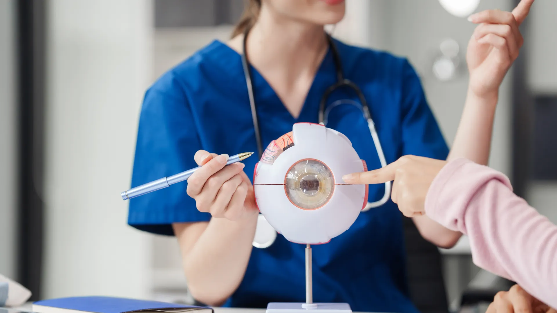 Ärztin erklärt diabetische Retinopathie am Auge.